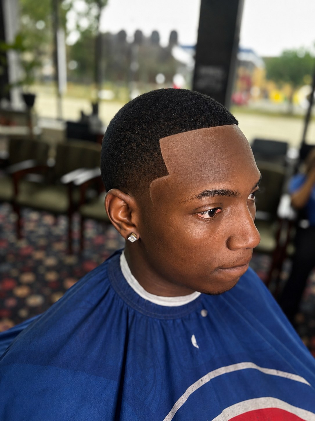 Sharp shape-up with a crisp angular hairline part, outdoor patio setting, cut by TaeChoppedHim in Mount Clemens, Michigan